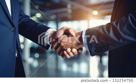 Businessmen handshake agreement inside modern office environment 132254750