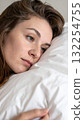 Young woman resting sideways on pillow with thoughtful look 132254755