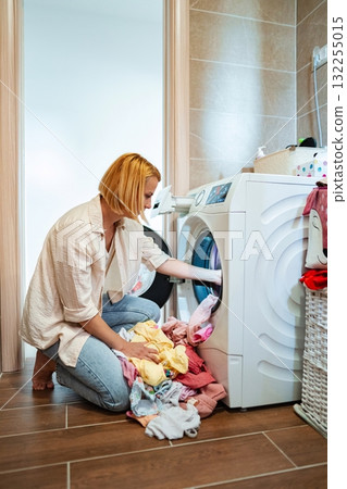 Laundry day routine featuring a woman in casual attire 132255015