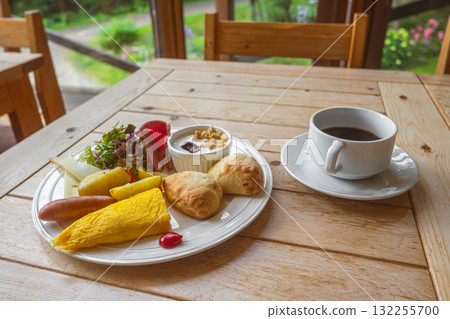Healthy breakfast plate with omelette, croissants, salad, and coffee on wooden table Healthy breakfast plate with omelette, croissants, salad, and coffee on wooden table 132255700