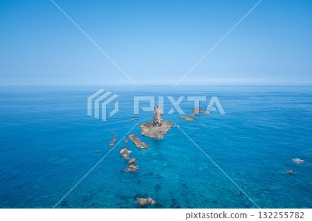 Rock formation rising from clear blue ocean under bright sky at Cape Kamui, Kozakicho, Hokkaido, Japan 132255782