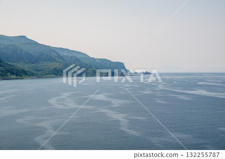 Coastal landscape with mountains and calm sea under clear sky at Cape Kamui, Kozakicho, Hokkaido, Japan 132255787