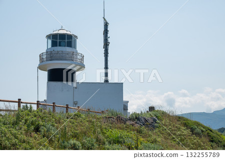 Lighthouse standing on grassy hill under clear sky near coastline at Cape Kamui, Kozakicho, Hokkaido, Japan Lighthouse standing on grassy hill under clear sky near coastline at Cape Kamui, Kozakicho, Hokkaido, Japan 132255789