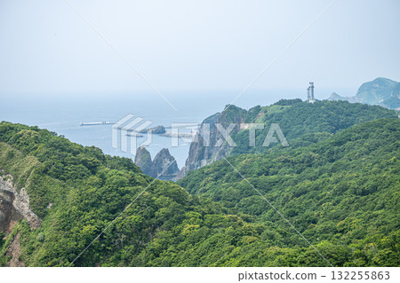 Lush green forested cliffs with lighthouse and ocean view on a hazy day at Cape Chikyu, Muroran, Hokkaido, Japan Lush green forested cliffs with lighthouse and ocean view on a hazy day at Cape Chikyu, Muroran, Hokkaido, Japan 132255863