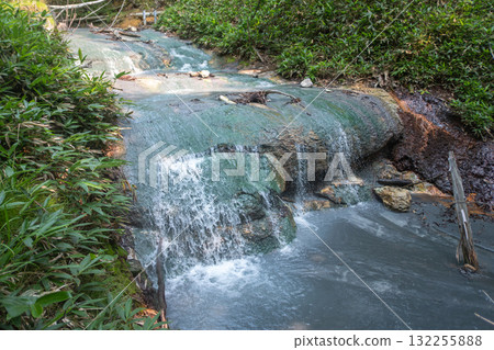 Small waterfall flowing over rocks in forest stream surrounded by greenery River Oyunuma Natural Footbath, Noboribetsu, Hokkaido, Japan 132255888