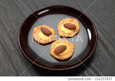 Rice crackers topped with almonds and cheese Rice crackers topped with almonds and cheese 132255937