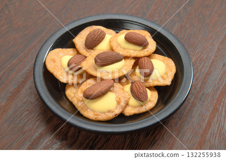 Rice crackers topped with almonds and cheese 132255938