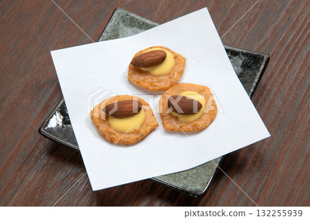 Rice crackers topped with almonds and cheese Rice crackers topped with almonds and cheese 132255939