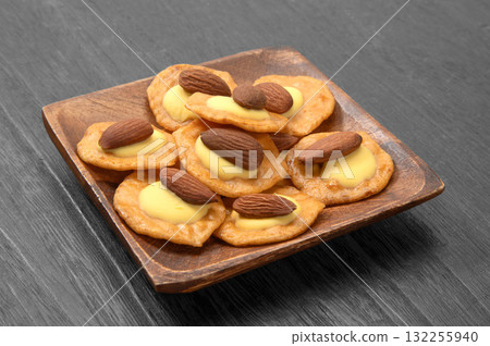 Rice crackers topped with almonds and cheese Rice crackers topped with almonds and cheese 132255940