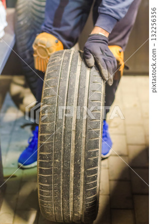 Mechanic Holding Used Car Tire Auto Maintenance Concept 132256356
