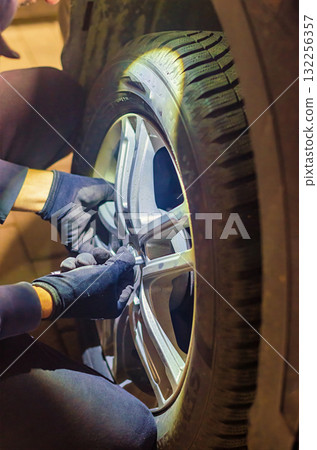 Mechanic Tightening Wheel Bolts with Wrench Car Tire Change 132256357