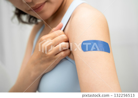 HPV, Human papillomavirus, Asian young woman receiving vaccine with blue bandage. 132256513