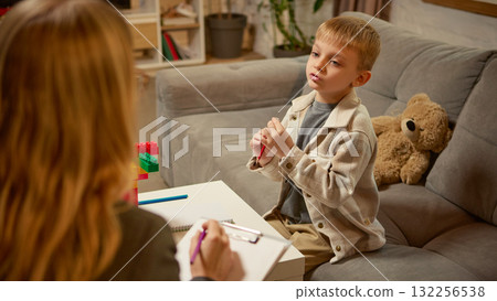 Boy explaining creative idea with toy blocks during psychology counseling session Boy explaining creative idea with toy blocks during psychology counseling session 132256538