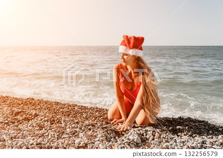 Santa's Beach Babe: A Woman in a Red Swimsuit and Santa Hat on the Beach Santa's Beach Babe: A Woman in a Red Swimsuit and Santa Hat on the Beach 132256579