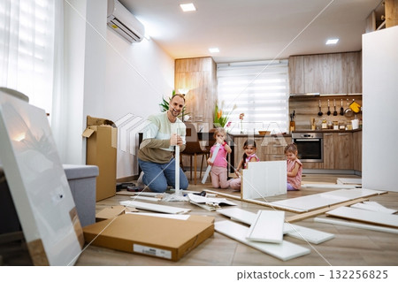 Family bonding through home assembly activity in a cozy kitchen 132256825