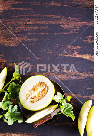Wooden board with ripe cut melons 132257384