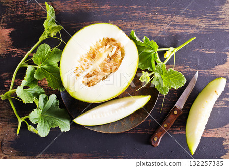 Wooden board with ripe cut melons 132257385