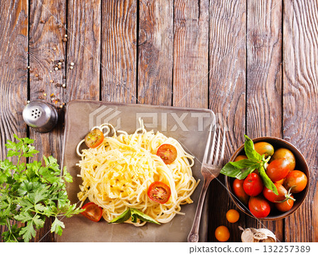 Delicious spaghetti with tomatoes on plate on table close-up 132257389