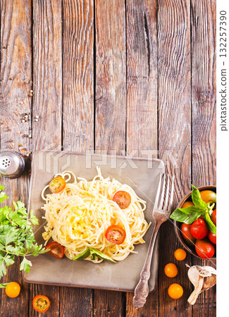 Delicious spaghetti with tomatoes on plate on table close-up Delicious spaghetti with tomatoes on plate on table close-up 132257390