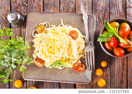 Delicious spaghetti with tomatoes on plate on table close-up Delicious spaghetti with tomatoes on plate on table close-up 132257393