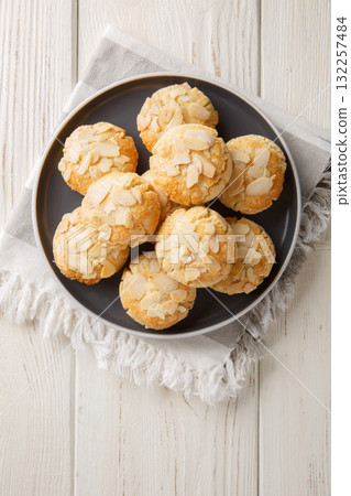 Cracked almond cookies vegetarian and gluten-free close-up in a plate. Vertical top view 132257484