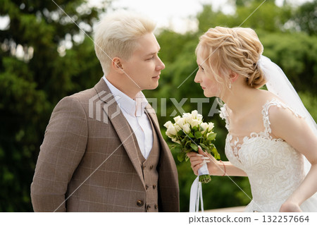 Couple exchanges loving glances during romantic outdoor wedding ceremony Couple exchanges loving glances during romantic outdoor wedding ceremony 132257664