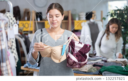 Young woman chooses underwear in clothing store Young woman chooses underwear in clothing store 132257821
