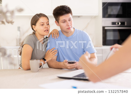 An insurance agent tells young couple the terms of property and life insurance 132257840