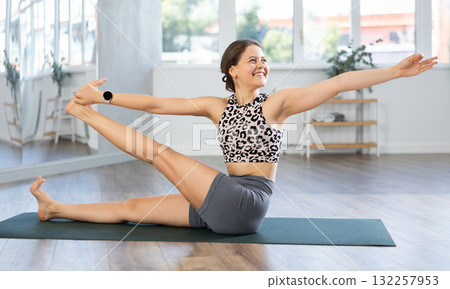 Young woman practicing yoga asanas in studio 132257953