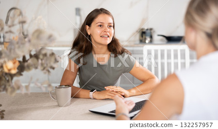 Girl talks to anb agent while sitting at table in kitchen Girl talks to anb agent while sitting at table in kitchen 132257957
