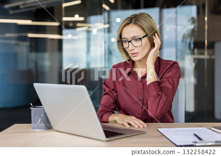 Sick woman suffering from ear inflammation and pain. Workplace worker working in office, otitis. Sick woman suffering from ear inflammation and pain. Workplace worker working in office, otitis. 132258422