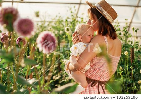 Little cute baby. Mother and daughter are in the greenhouse 132259186