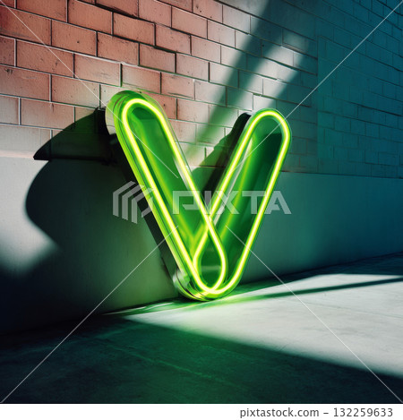 A large neon sign with the letter V in a bold, sans-serif font, set against a brick wall backdrop. The lighting is soft and diffused, casting gentle shadows on the ground below the sign. A large neon sign with the letter V in a bold, sans-serif font, set against a brick wall backdrop. The lighting is soft and diffused, casting gentle shadows on the ground below the sign. 132259633