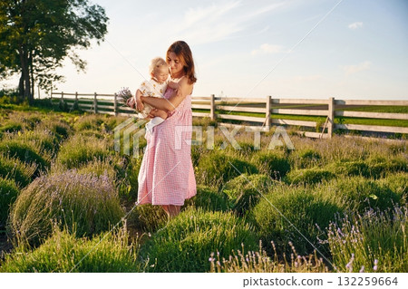 Holding baby in hands. Beautiful mother with her daughter on the farm 132259664