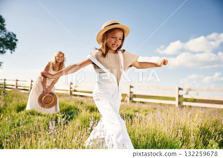 Running, having fun. Beautiful mother with her daughter on the farm 132259678