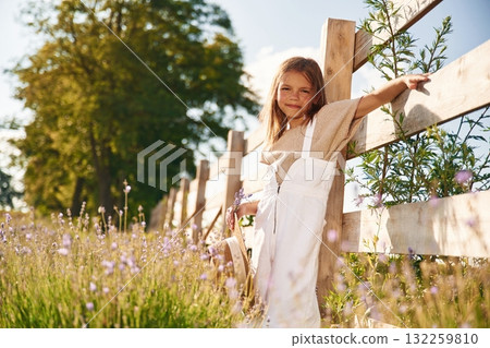 Leaning on the wooden fence. Cute little girl is on the farm Leaning on the wooden fence. Cute little girl is on the farm 132259810