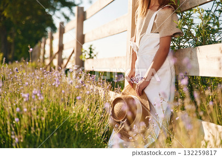 Leaning on the wooden fence. Cute little girl is on the farm 132259817