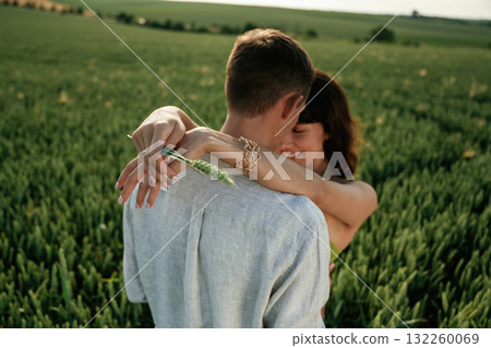 Closeness of the people, embracing. Lovely couple are on the agricultural field together Closeness of the people, embracing. Lovely couple are on the agricultural field together 132260069