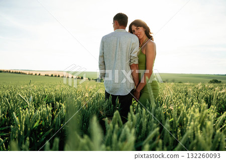 Under the sunlight, enjoying each other. Lovely couple are on the agricultural field together Under the sunlight, enjoying each other. Lovely couple are on the agricultural field together 132260093