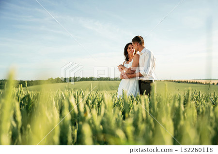 Against beautiful landscape. Lovely couple are on the agricultural field together Against beautiful landscape. Lovely couple are on the agricultural field together 132260118