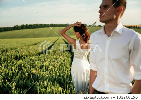 Wedding clothes. Lovely couple are on the agricultural field together Wedding clothes. Lovely couple are on the agricultural field together 132260150