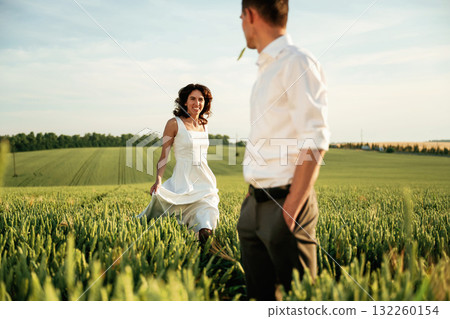 After the wedding. Lovely couple are on the agricultural field together After the wedding. Lovely couple are on the agricultural field together 132260154
