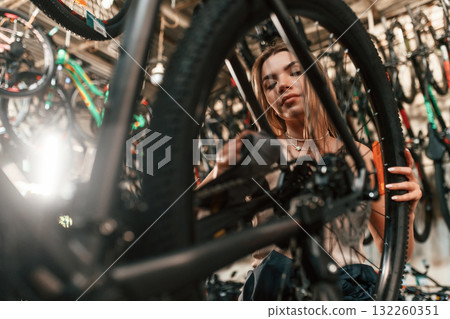 Repair woman in bicycle shop, working in store Repair woman in bicycle shop, working in store 132260351
