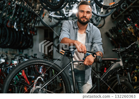 Beautiful portrait. Repair man in bicycle shop, working in store Beautiful portrait. Repair man in bicycle shop, working in store 132260363