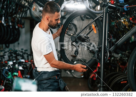 Working in the store. Repair man in bicycle shop 132260382