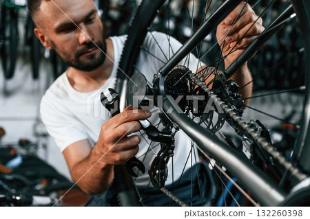 Checking the wheel and brake system. Repair man in bicycle shop, working in store 132260398