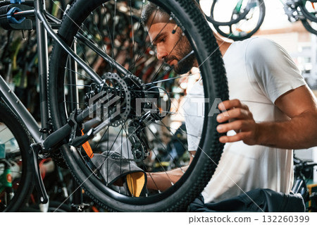 Cleaning the chain. Repair man in bicycle shop, working in store Cleaning the chain. Repair man in bicycle shop, working in store 132260399