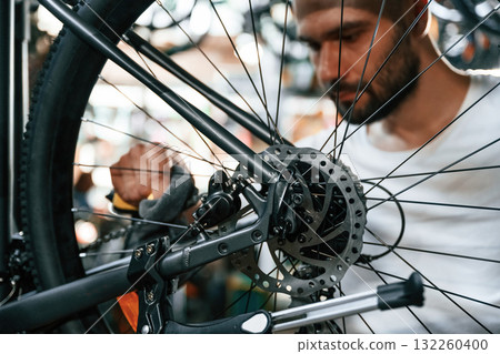 Cleaning the chain. Repair man in bicycle shop, working in store Cleaning the chain. Repair man in bicycle shop, working in store 132260400