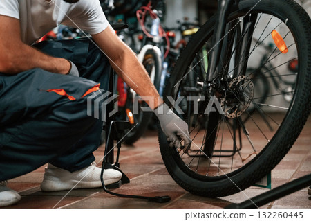 Inflates a tire with hand pump. Close up view of man's hands that is repairing bicycle Inflates a tire with hand pump. Close up view of man's hands that is repairing bicycle 132260445