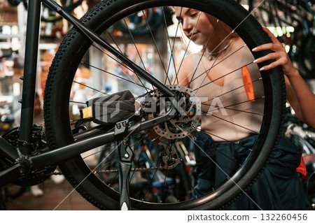 Making it clean. Repair woman in bicycle shop, working in store Making it clean. Repair woman in bicycle shop, working in store 132260456